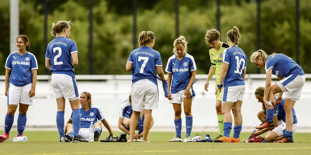 Fußballerinnen von Holstein Kiel stehen auf einem Fußballplatz. Fußballerinnen von Holstein Kiel stehen auf einem Fußballplatz.
