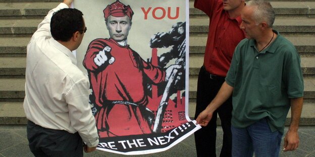 Drei Männer halten ein Plakat, auf dem Putin und der Schriftzug "Georgien 2008 - you are the next" abgebildet ist Drei Männer halten ein Plakat, auf dem Putin und der Schriftzug "Georgien 2008 - you are the next" abgebildet ist