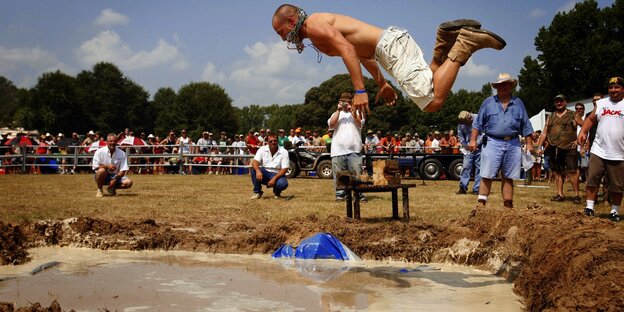 Bei den Redneck Games springt der Hinterwäldner in ein Becken Schlamm