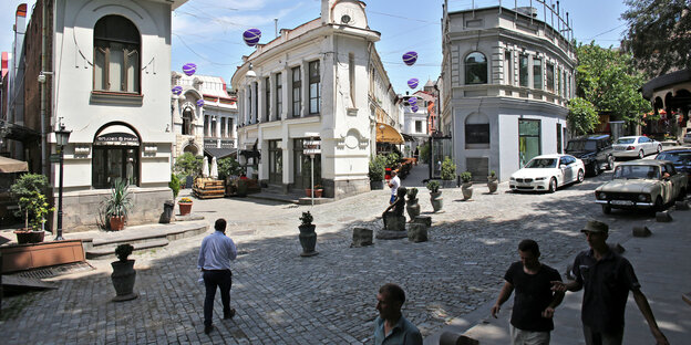 Auf einem Platz in Tiflis in Georgien laufen Menschen