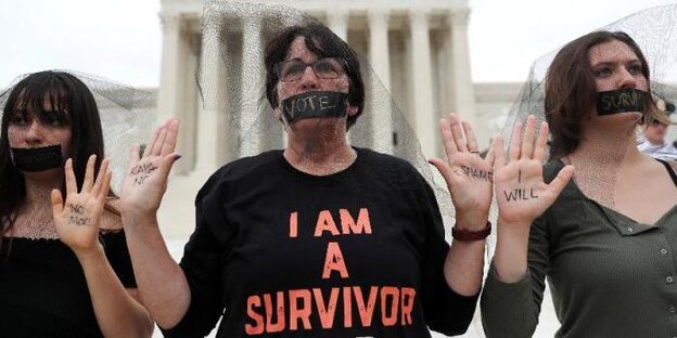 Drei Frauen protestieren vor dem Capitol in Washington. Ihre Münder sind mit Klebeband zugeklebt Drei Frauen protestieren vor dem Capitol in Washington. Ihre Münder sind mit Klebeband zugeklebt
