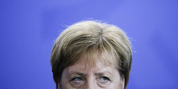 Das Gesicht von Angela Merkel von der Nase hin nach oben vor einer violetten Wand Das Gesicht von Angela Merkel von der Nase hin nach oben vor einer violetten Wand