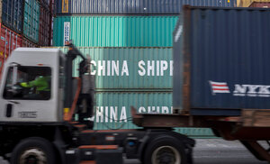 Ein Lastwagen fährt im Hafen von Savannah an Containern aus China vorbei Ein Lastwagen fährt im Hafen von Savannah an Containern aus China vorbei
