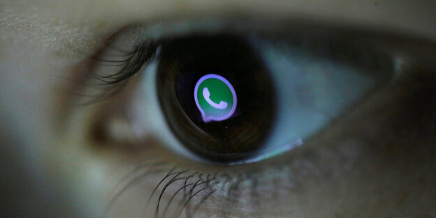 Ein menschliches braunes Auge, in dessen Pupille sich das grün-weiße WhatsApp Logo wiederspiegelt. Ein menschliches braunes Auge, in dessen Pupille sich das grün-weiße WhatsApp Logo wiederspiegelt.