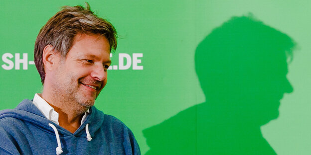 Robert Habeck vor einer grünen Wand Robert Habeck vor einer grünen Wand