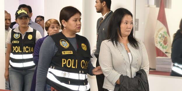 Eine Polizistin führt Keiko Fujimori vor sich her Eine Polizistin führt Keiko Fujimori vor sich her
