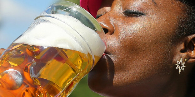 Frau trinkt Bier aus Maß Frau trinkt Bier aus Maß
