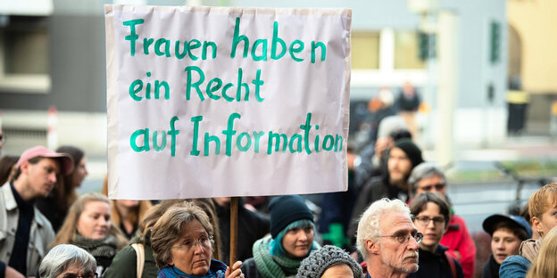 Eine Frau hält bei einer Kundgebung vor Beginn eines Berufungsprozesses gegen die Gießener Ärztin Hänel am Landgericht ein Plakat mit der Aufschrift „Frauen haben ein Recht auf Information“ Eine Frau hält bei einer Kundgebung vor Beginn eines Berufungsprozesses gegen die Gießener Ärztin Hänel am Landgericht ein Plakat mit der Aufschrift „Frauen haben ein Recht auf Information“