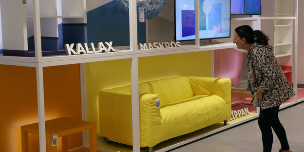 Eine Frau guckt auf Möbel bei Ikea Eine Frau guckt auf Möbel bei Ikea