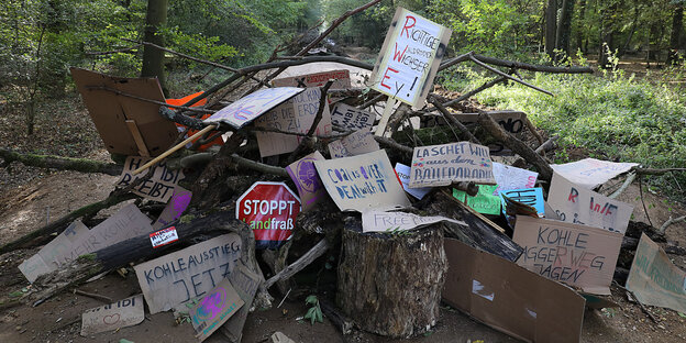 Im Hambacher Forst liegen Protestplakate auf einem Haufen Im Hambacher Forst liegen Protestplakate auf einem Haufen