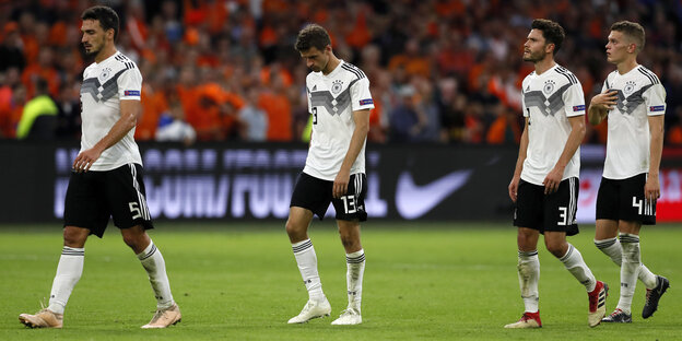 Vier Fußballer der deutschen Nationalelf gehen mit gesenkten Köpfen vom Platz Vier Fußballer der deutschen Nationalelf gehen mit gesenkten Köpfen vom Platz