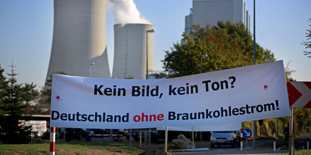 Banner mit der Aufschrift "Kein Bild, kein Ton. Deutschland ohne Braunkohlestrom" vor dem qualmenden Kraftwerk Neurath Banner mit der Aufschrift "Kein Bild, kein Ton. Deutschland ohne Braunkohlestrom" vor dem qualmenden Kraftwerk Neurath