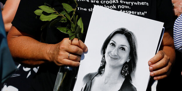 Eine Person hält ein Foto von Daphne Galizia Eine Person hält ein Foto von Daphne Galizia