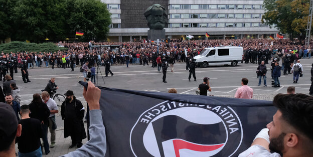 Zwei Teilnehmer einer Gegendemonstration gegen Rechts hebe eine Antifa-Fahne in die Luft Zwei Teilnehmer einer Gegendemonstration gegen Rechts hebe eine Antifa-Fahne in die Luft