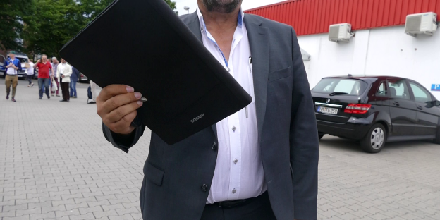 Ein Mann versucht, einen Fotografen bei seiner Arbeit zu behindern Ein Mann versucht, einen Fotografen bei seiner Arbeit zu behindern