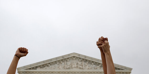 Demonstrantinnen vor dem Supreme Court in Washington haben ihre Arme in die Luft gehoben Demonstrantinnen vor dem Supreme Court in Washington haben ihre Arme in die Luft gehoben