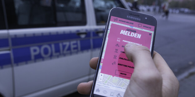 Ein Smartphone mit dem Eingabeformular der "Cop-Map" vor einem Polizeiauto Ein Smartphone mit dem Eingabeformular der "Cop-Map" vor einem Polizeiauto