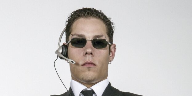 Ein Security-Mitarbeiter mit Sonnenbrille und Headset. Ein Security-Mitarbeiter mit Sonnenbrille und Headset.
