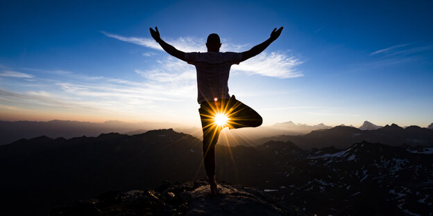 Yoga - Mensch in Yoga-Pose vor der tief stehenden Sonne Yoga - Mensch in Yoga-Pose vor der tief stehenden Sonne