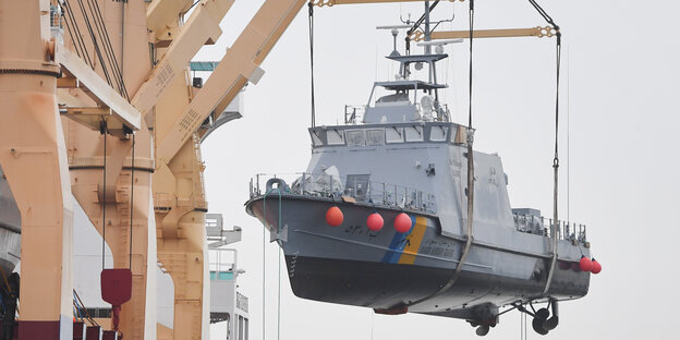 Ein Patrouillenboot wird von einem Kran verladen Ein Patrouillenboot wird von einem Kran verladen