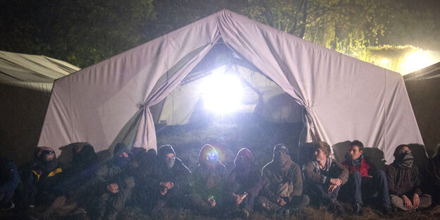Aktivisten des Aktionsbündnisses «Ende Gelände» sitzen kurz vor der Räumung ihres Camps vor einem Zelt. Aktivisten des Aktionsbündnisses «Ende Gelände» sitzen kurz vor der Räumung ihres Camps vor einem Zelt.