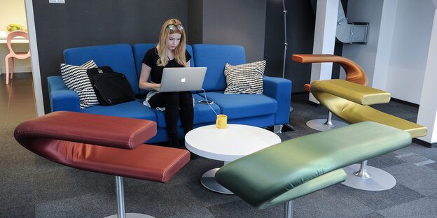 Eine Frau sitzt im Google Campus in Warschau an ihrem Computer Eine Frau sitzt im Google Campus in Warschau an ihrem Computer