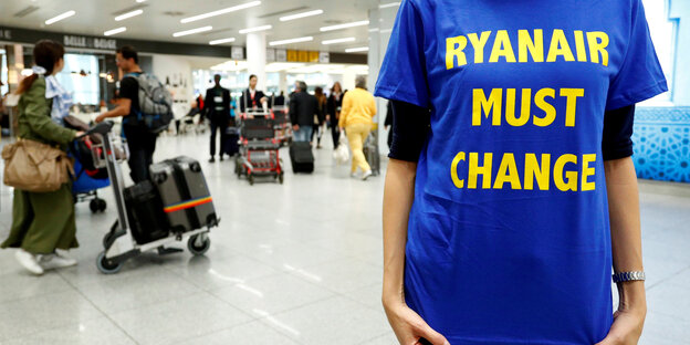 Eine Frau trägt ein T-Shirt mit der Aufschrift "Ryanair must change" Eine Frau trägt ein T-Shirt mit der Aufschrift "Ryanair must change"