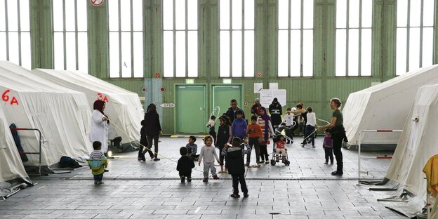 Geflüchtete Kinder und Erwachsenen in den Hangars des ehemaligen Flughafen Tempelhof Geflüchtete Kinder und Erwachsenen in den Hangars des ehemaligen Flughafen Tempelhof