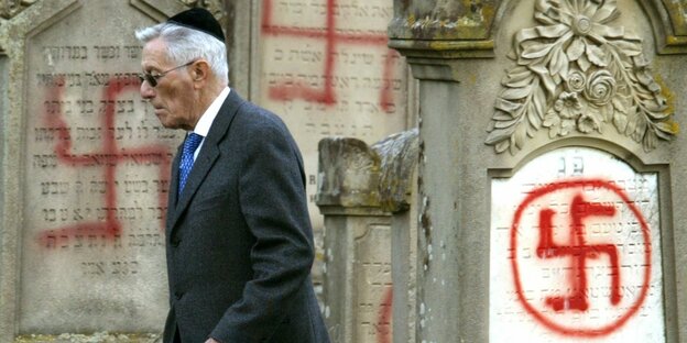 Ein Mann mit Kipa begutachtet den mit Hakenkreuzen geschändeten Friedhof in Colmar Ein Mann mit Kipa begutachtet den mit Hakenkreuzen geschändeten Friedhof in Colmar