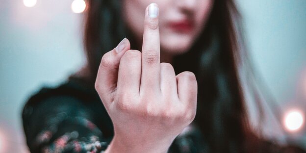 Eine Frau zeigt den Mittelfinger Eine Frau zeigt den Mittelfinger