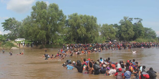 Flüchtende durchschwimmen eine Grenzfluss