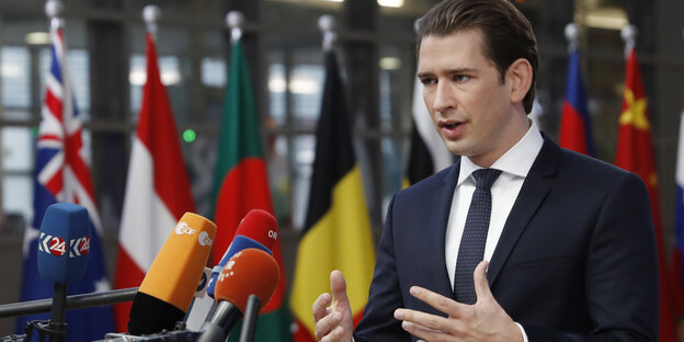 Sebastian Kurz steht den Flaggen europäischer Länder und spricht in mehrere Mirkos. Sebastian Kurz steht den Flaggen europäischer Länder und spricht in mehrere Mirkos.