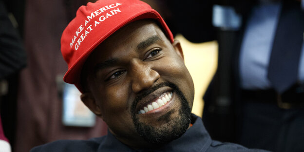 Rapper Kanye West trägt breit grinsend eine "Make America Great Again"-Kappe. Rapper Kanye West trägt breit grinsend eine "Make America Great Again"-Kappe.