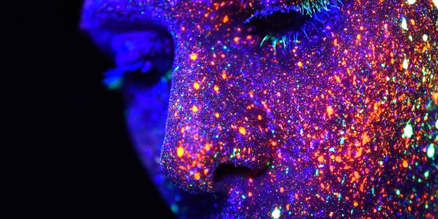 Auf dem Körper und Gesicht einer Frau sind viele bunte Punkte zu sehen Auf dem Körper und Gesicht einer Frau sind viele bunte Punkte zu sehen