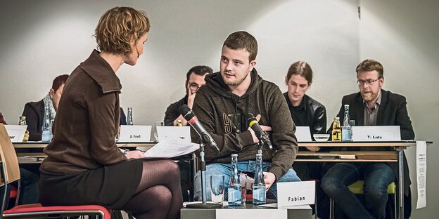 Ein junger Mann spricht mit einer Frau beim Hamburger "Tribunal zur Heimerziehung". Ein junger Mann spricht mit einer Frau beim Hamburger "Tribunal zur Heimerziehung".