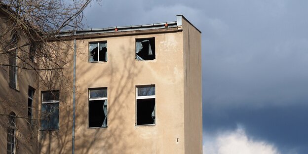 mehrstöckiges Haus mit kaputten Fenstern vor blauem Himmel mehrstöckiges Haus mit kaputten Fenstern vor blauem Himmel