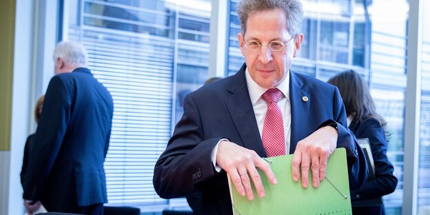 Hans Georg Maaßen packt Akten in seine tasche, im Hintergrund tritt Horst Seehofer aus dem Raum Treppengitter und hat beide Ellenbogen auf die Knie gestützt Hans Georg Maaßen packt Akten in seine tasche, im Hintergrund tritt Horst Seehofer aus dem Raum Treppengitter und hat beide Ellenbogen auf die Knie gestützt