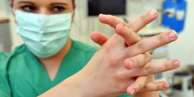 Eine Krankenschwester reinigt sich die Hände Eine Krankenschwester reinigt sich die Hände