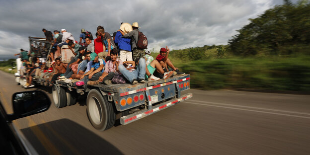 Mittelamerikanische Migranten fahren auf einem Lastwagen mit Mittelamerikanische Migranten fahren auf einem Lastwagen mit