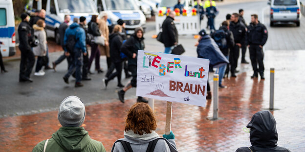 Demonstranten mit einem Schild mit der Aufschrift "Lieber bunt statt braun". Demonstranten mit einem Schild mit der Aufschrift "Lieber bunt statt braun".