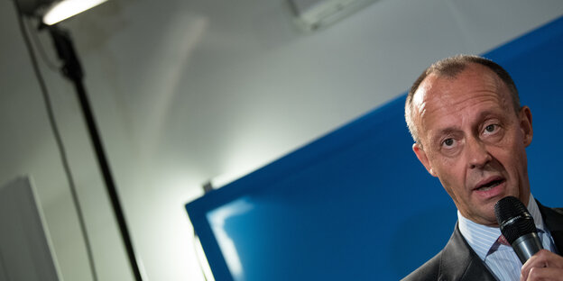 Friedrich Merz mit einem Mikrophon in der Hand Friedrich Merz mit einem Mikrophon in der Hand
