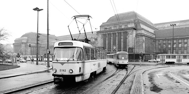 Eine schwarz-weiße Straßenbahn fährt über Schienen vor dem Leipziger Bahnhof. Eine schwarz-weiße Straßenbahn fährt über Schienen vor dem Leipziger Bahnhof.