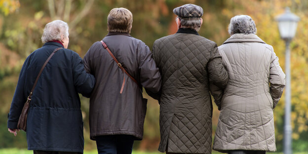 Drei ältere Personen laufen durch den Park Drei ältere Personen laufen durch den Park
