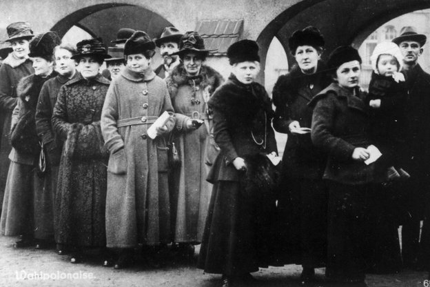 Eine Schwarz-Weiß-Fotografie zeigt mehrere Frauen die in einer Reihe stehen Eine Schwarz-Weiß-Fotografie zeigt mehrere Frauen die in einer Reihe stehen