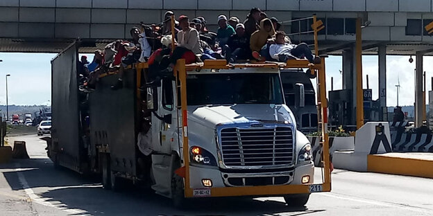 Migranten aus Mittelamerika fahren auf einem LKW durch eine Mautstation in Mexiko Migranten aus Mittelamerika fahren auf einem LKW durch eine Mautstation in Mexiko