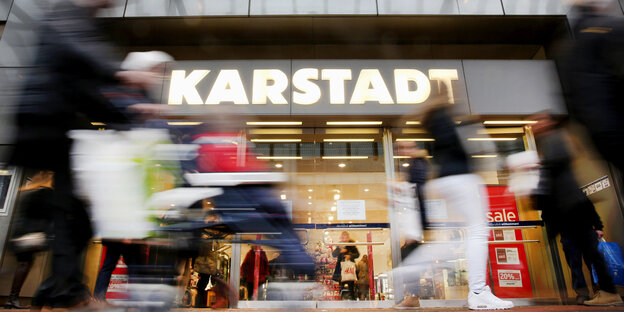 Menschen laufen vor einem Karstadt-Eingang entlang Menschen laufen vor einem Karstadt-Eingang entlang