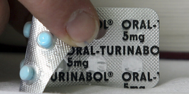 Ein Finger auf einer Pillenpackung Ein Finger auf einer Pillenpackung