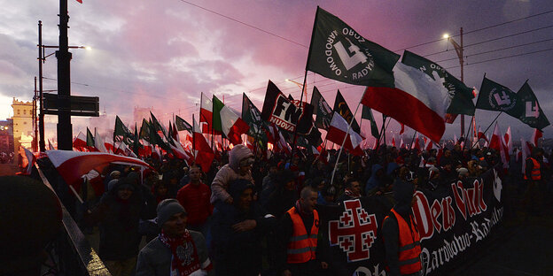 Menschen auf einer Demonstration, u.a. polnische Flaggen werden geschwungen Menschen auf einer Demonstration, u.a. polnische Flaggen werden geschwungen