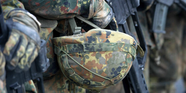 Ein Bundeswehrhelm und eine Waffe Ein Bundeswehrhelm und eine Waffe