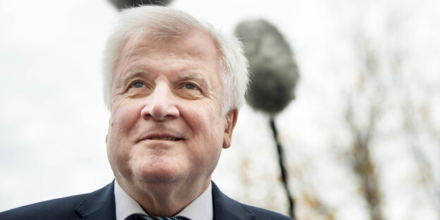 Nahaufnahme von Horst Seehofer im Freien, über ihm hängen Mikrofone mit Windschutz Nahaufnahme von Horst Seehofer im Freien, über ihm hängen Mikrofone mit Windschutz